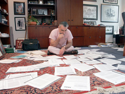 Scalea sitting on floor with papers